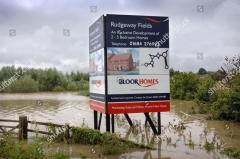 a-sign-advertising-a-new-housing-development-in-a-flood-plain-tewkesbury